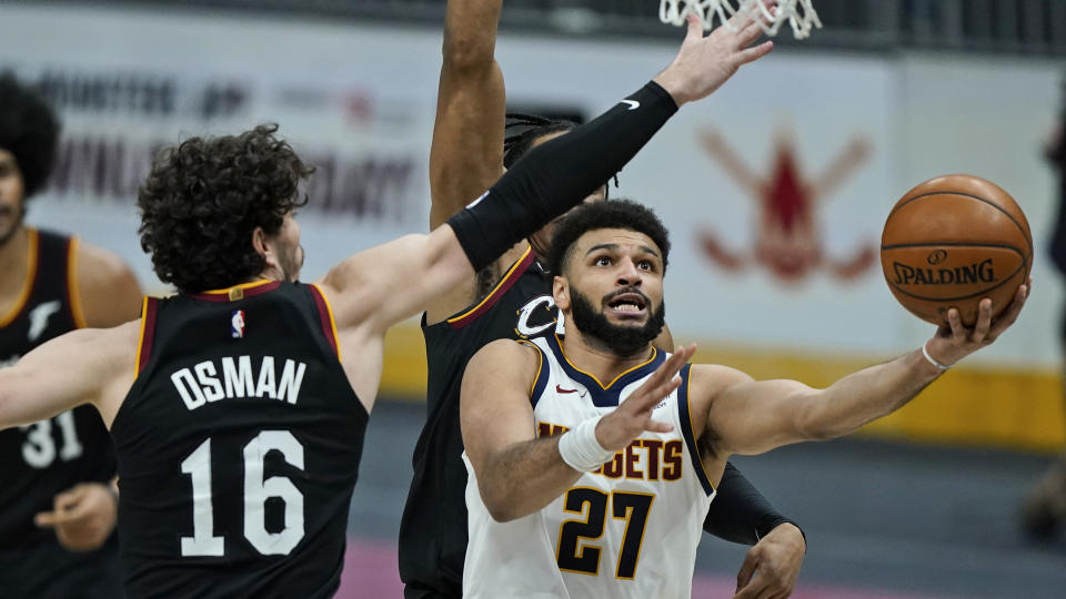 Denver Nuggets' Jamal Murray (27) drives to the basket against Cleveland Cavaliers' Cedi Osman (16) during the second half of an NBA basketball game, Friday, Feb. 19, 2021, in Cleveland. (AP Photo/Tony Dejak)