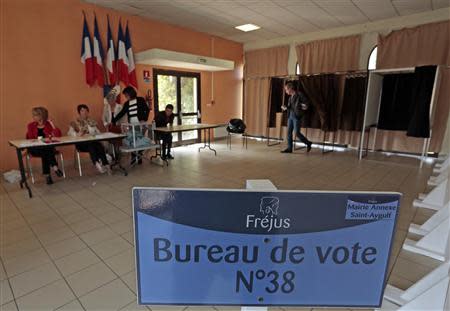 A voter leaves a polling booth in as he prepares to cast his ballot during the second round of the French municipal elections in Frejus March 30, 2014. REUTERS/Eric Gaillard