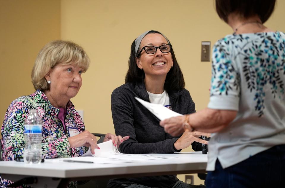 Poll workers, Darla Hunter, left, and Pat Kubicek, hand out ballots during the Kentucky primary election at the main branch of the Boone County Public Library.