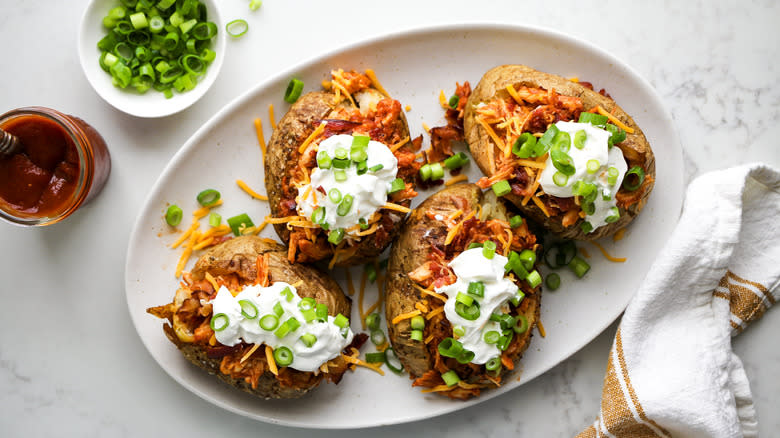 loaded chicken bbq baked potatoes on platter