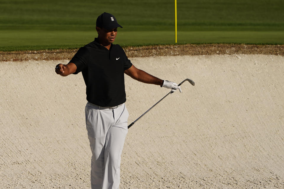 Tiger Woods reaches after his bunker shot on the second hole during the second round of the Masters golf tournament Friday, Nov. 13, 2020, in Augusta, Ga. (AP Photo/Matt Slocum)