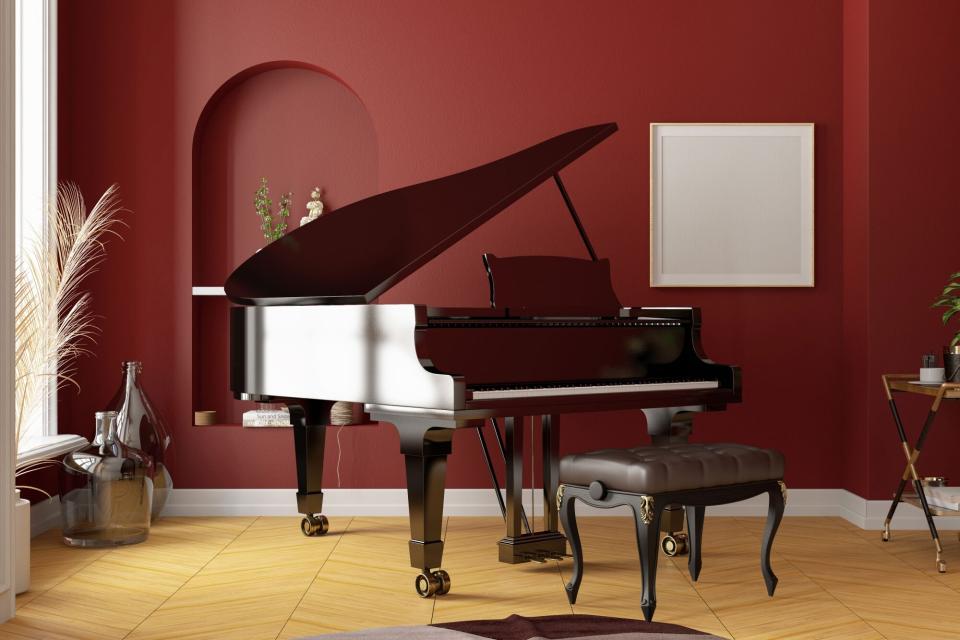 Bold red wall in room with piano for entertaining