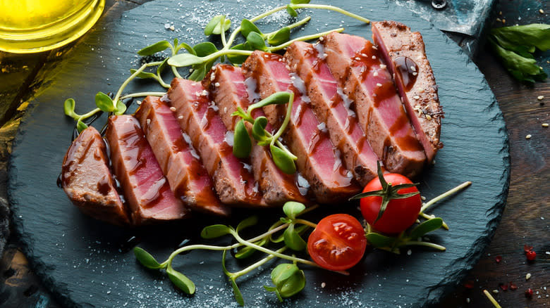 Sliced tuna with greens and tomatoes