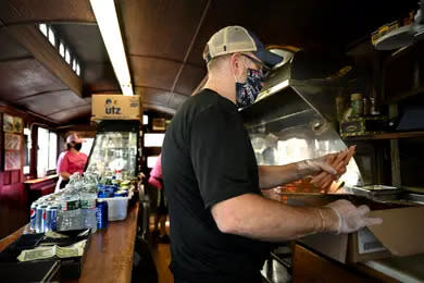 Patrick Casey, owner of Casey's Diner, prepares to cook a fistful of his famous steamed hot dogs in this 2020 file photo.