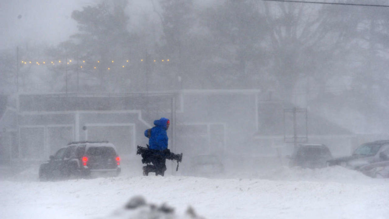 HAMBURG, NY - DECEMBER 23: A member of the media battles snow and ice as  Lake Erie waters wash over the shoreline on December 23, 2022 in Hamburg, New York. The Buffalo suburb and surrounding area are expecting wind gusts over 70 miles per hour battering homes and businesses through out the holiday weekend.  (Photo by John Normile/Getty Images)