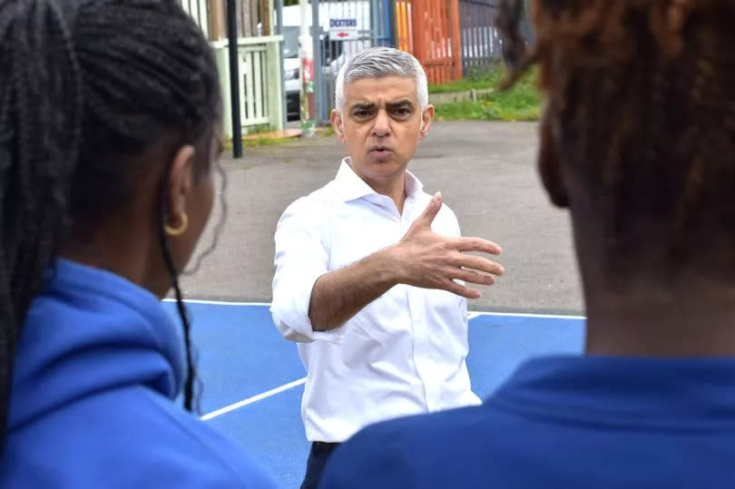 Sadiq Khan speaking to young people in Brixton wearing a white shirt