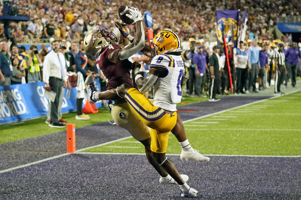 CORRECTS TO 21-YARD TOUCHDOWN NOT 20-YARD TOUCHDOWN - Florida State wide receiver Keon Coleman, left, makes a reception over LSU safety Major Burns (8) for a 21-yard touchdown during the first half of an NCAA college football game Sunday, Sept. 3, 2023, in Orlando, Fla. (AP Photo/John Raoux)