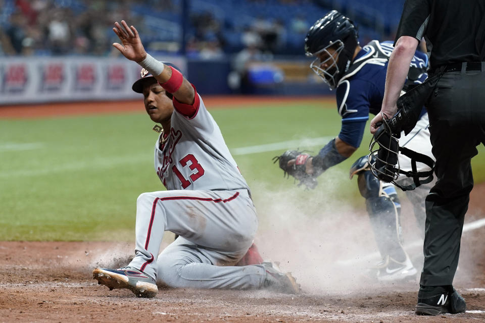 Washington Nationals' Starlin Castro scores ahead of the tag by Tampa Bay Rays catcher Francisco Mejia on a sacrifice fly by Josh Harrison during the 11th inning of a baseball game Wednesday, June 9, 2021, in St. Petersburg, Fla. (AP Photo/Chris O'Meara)