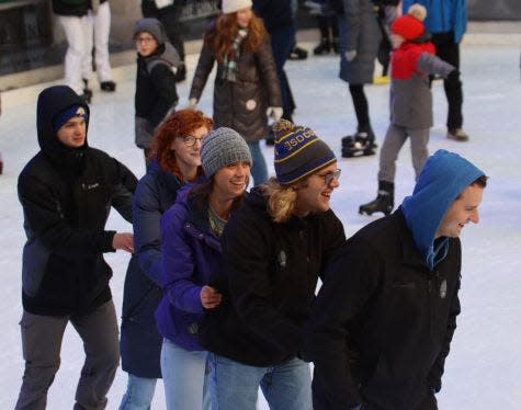 From left, Pride members David Delahoyde, Cadence Helleson, Jessica Begeman, Matthew Dulas and Benjamin Leek skate together at Rockefeller Plaza.