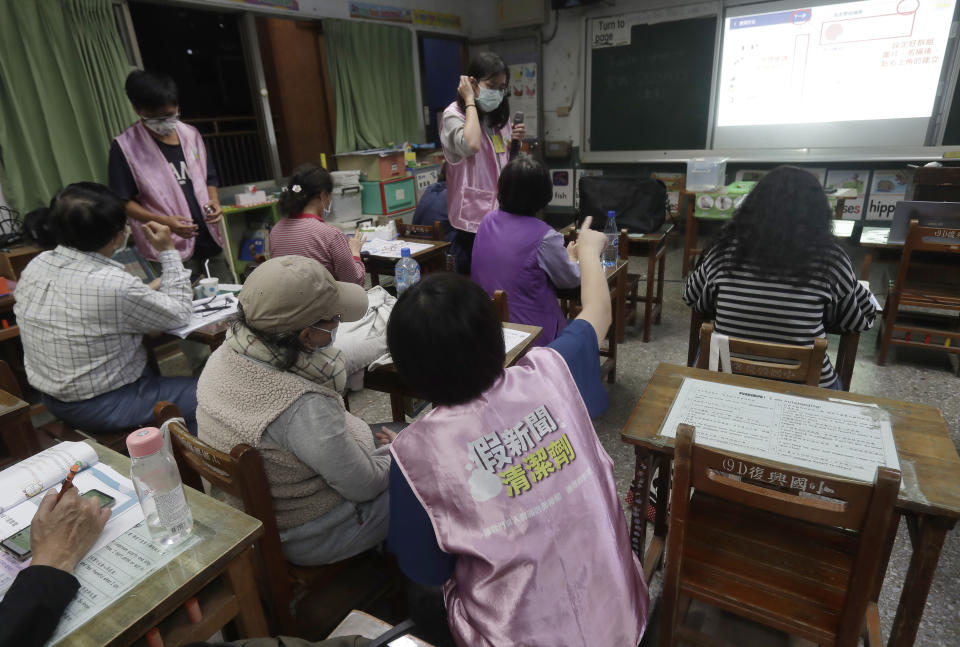 Volunteers of Fake News Cleaner guide students through the LINE app to identify fake news during a class in Kaohsiung City, southern Taiwan, Thursday, March 16, 2023. An anti-misinformation group in Taiwan called Fake News Cleaner has hosted more than 500 events, connecting with college students, elementary-school children — and the seniors that, some say, are the most vulnerable to such efforts. (AP Photo/Chiang Ying-ying)
