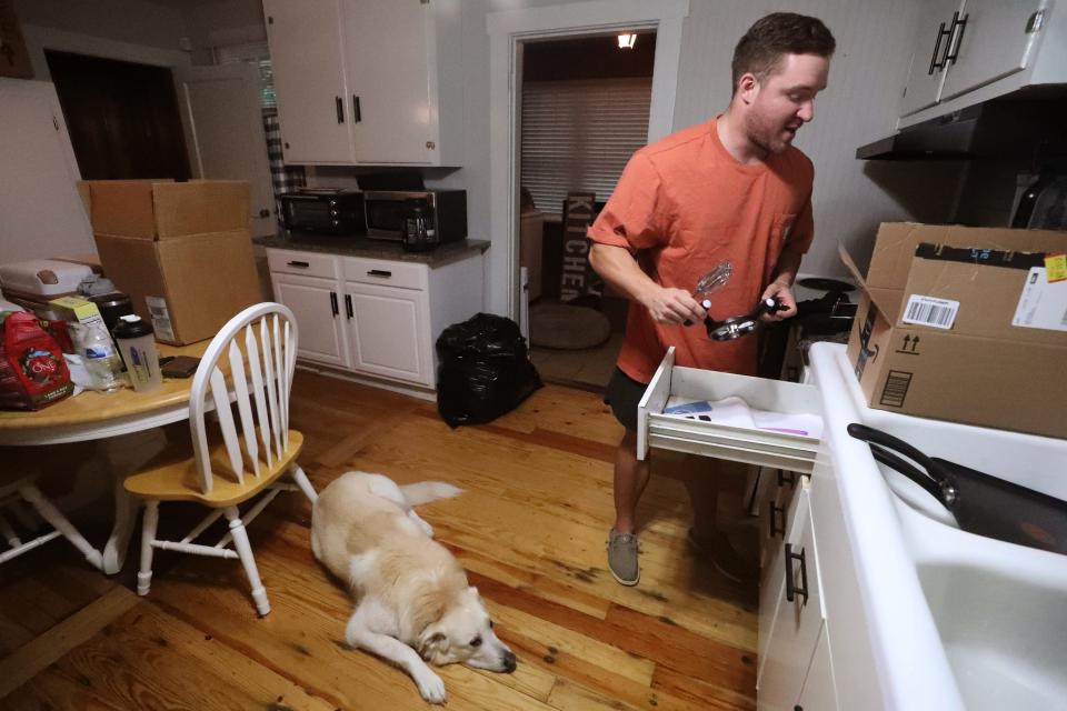 Jake Bolden packs moving boxes in the kitchen of his rental home, in Murfreesboro, on Tuesday, July 18, 2023, under the watchful eye of his dog Ellie Mae while he gets ready to move with his wife Elizabeth Ivey-Bolden, to their first purchased home in Shelbyville.