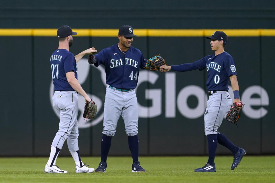 Seattle Mariners' Jesse Winker (27), Julio Rodriguez (44) and Sam Haggerty (0) celebrate the team's 8-3 win in a baseball game against the Texas Rangers, Friday, July 15, 2022, in Arlington, Texas. (AP Photo/Tony Gutierrez)