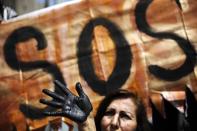 <p>An activist with her hand painted black to symbolize the contamination of oil takes part in a protest performance demanding measures to prevent oil spills, outside the national oil company in Lima, Peru, Aug. 22, 2016. (Photo: Rodrigo Abd/AP) </p>