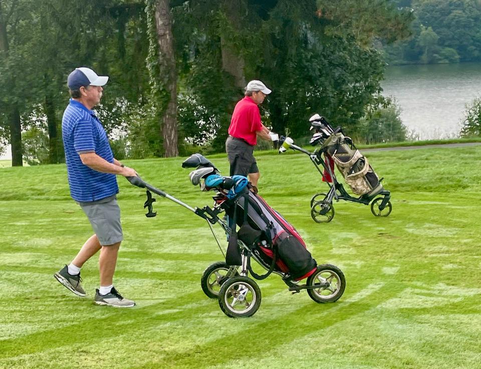 From left, Kevin Tivnan and Bruce Chansky push their carts at Green Hill.