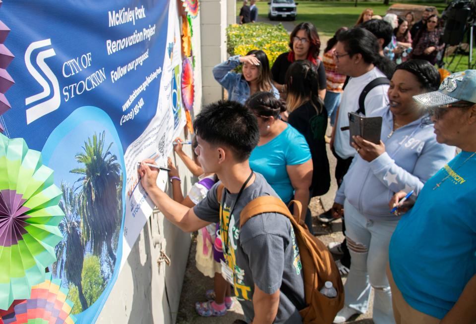 People sign a banner at the groundbreaking ceremony for extensive renovations to the park in south tStockton on Apr. 23, 2024.