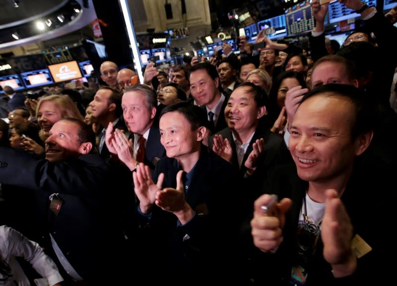 Alibaba Group Holding Ltd founder Jack Ma (C) applauds at the New York Stock Exchange before his company's initial public offering (IPO) under the ticker "BABA" in New York September 19, 2014. REUTERS/Brendan McDermid