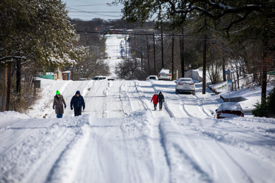 Pedestrians walk on an icy road in East Austin, Texas, on February 15, 2021<span class="copyright">Montinique Monroe— Getty Images</span>