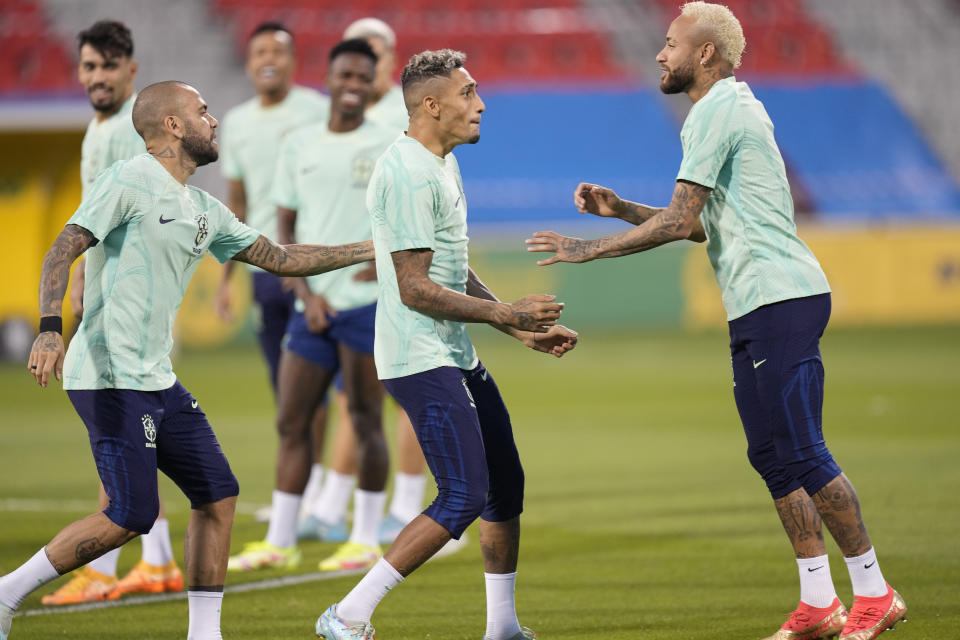 Los brasileños Neymar (derecha), Raphinha (centro) y Dani Alves durante un entrenamiento en Doha, Qatar, el jueves 8 de diciembre de 2022 .Brasil enfrentará a Croacia en en los cuartos de final el viernes. (AP Foto/Andre Penner)