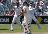 England's captain Alastair Cook (L) and Matt Prior (R) celebrate the dismissal of Australia's Chris Rogers during the third day of the second Ashes test cricket match at the Adelaide Oval December 7, 2013.