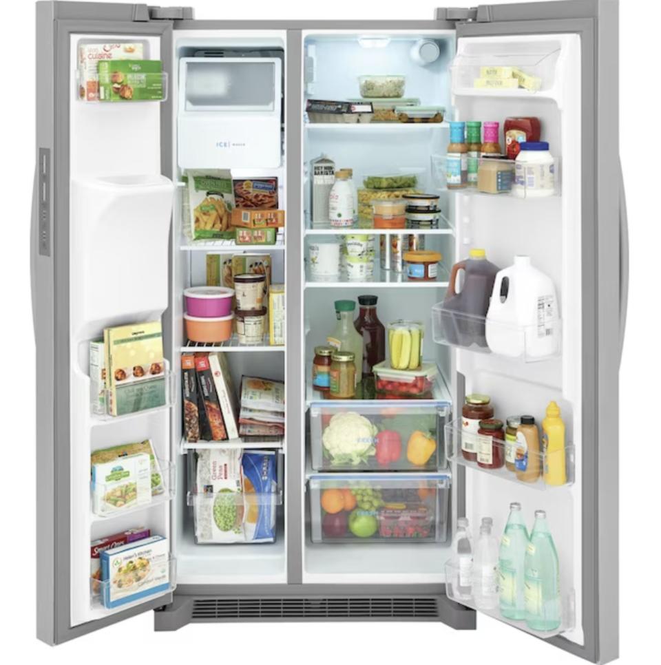 Fully stocked open refrigerator showing various fresh fruits, vegetables, dairy products, beverages, condiments, and frozen meals