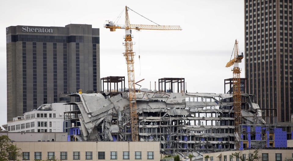 Debris hangs on the side of the building after a large portion of a hotel under construction suddenly collapsed in New Orleans on Saturday, Oct. 12, 2019. Several construction workers had to run to safety as the Hard Rock Hotel, which has been under construction for the last several months, came crashing down. It was not immediately clear what caused the collapse or if anyone was injured. (David Grunfeld/The Advocate via AP)