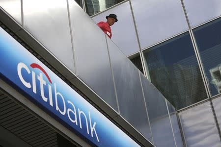 A man watches police officers make arrests as protesters from political activist group 99 Rise stage a sit-in at the entrance of a CitiBank branch office in Los Angeles, California October 25, 2012. REUTERS/David McNew