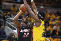 Miami Heat forward Jimmy Butler (22) shoots as Indiana Pacers forward Justin Holiday (8) defends during the first half of an NBA basketball game in Indianapolis, Saturday, Oct. 23, 2021. (AP Photo/Doug McSchooler)