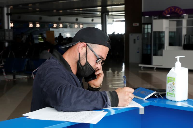 Ukrainian worker Diachenko fills in documents before his departure for Poland at an airport outside Kiev