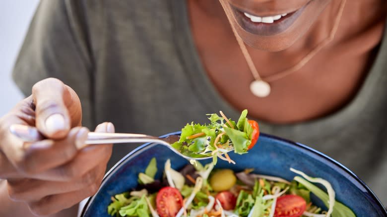 smiling woman eating salad