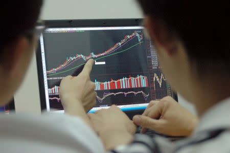 Students point at a laptop screen showing stock information, in Beijing, in the June 15, 2007 file picture. REUTERS/Stringer/Files