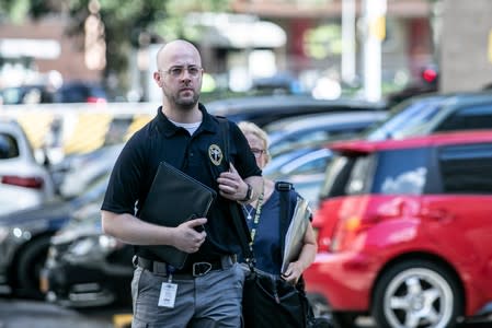 Medical Examiners walk outside Metropolitan Correctional Center jail where financier Jeffrey Epstein, who was found dead in the Manhattan borough of New York City