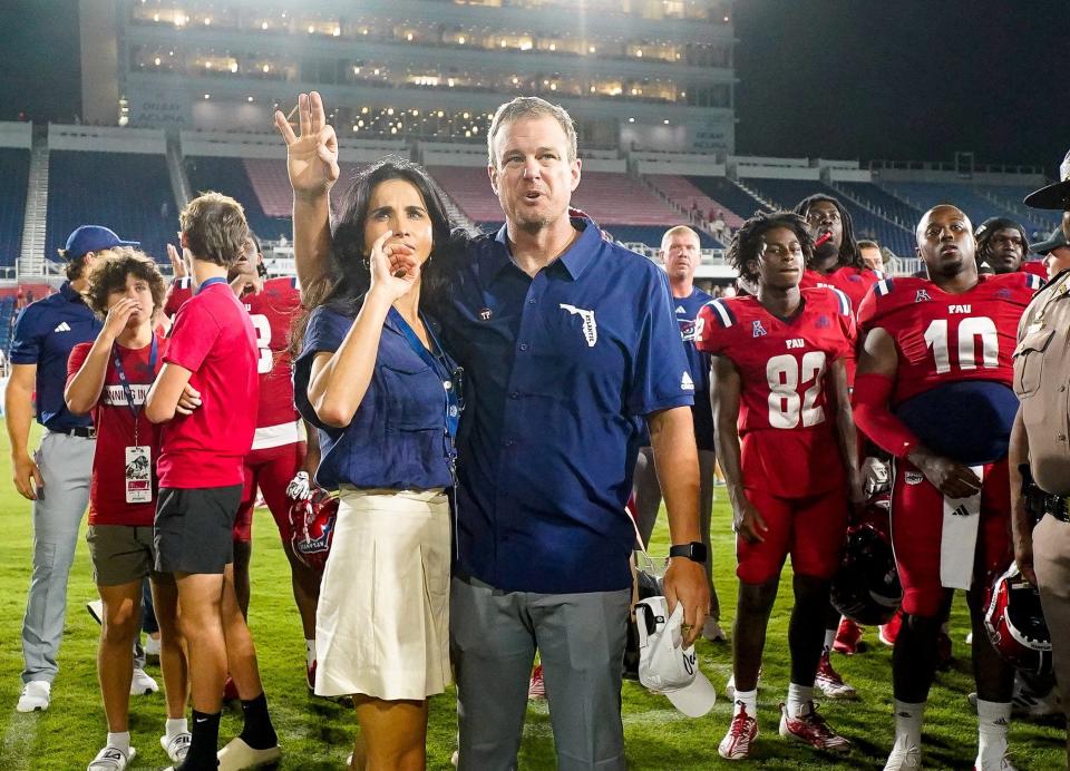 Florida Atlantic head coach Tom Herman and his wife Michelle salute the band and student section after a 42-20 victory over Monmouth at FAU Stadium on Saturday, September 2, 2023, in Boca Raton, FL.