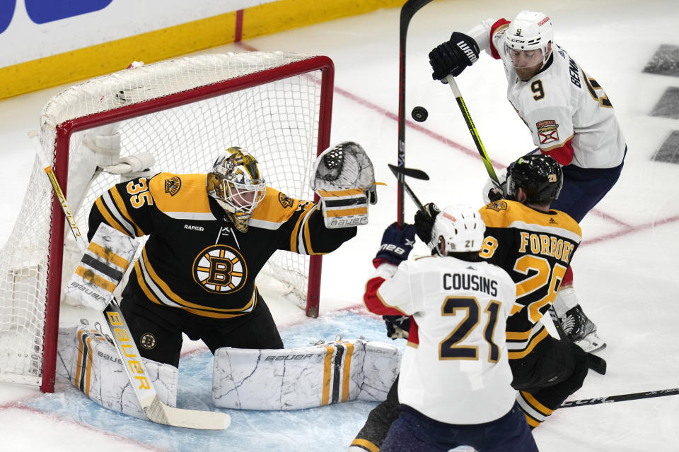 Boston Bruins goaltender Linus Ullmark (35) reaches up for the puck while pressured by Florida Panthers center Sam Bennett (9) during the first period of Game 5 in the first round of the NHL hockey playoffs, Wednesday, April 26, 2023, in Boston. (AP Photo/Charles Krupa)