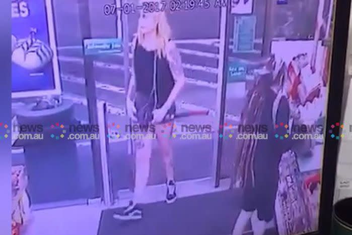 The axe-wielding woman can be seen entering the Enmore 7-Eleven in the early hours of Saturday morning. Source: News Corp