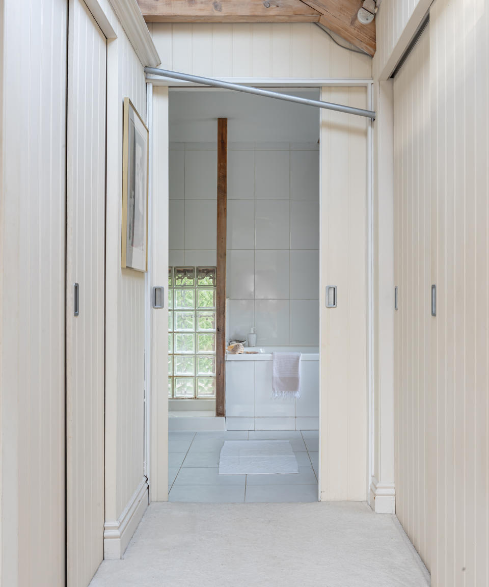 Hallway with fitted wardrobes and panelled sliding doors leading to the bathroom