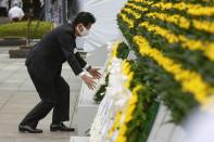 Japan's Prime Minister Shinzo Abe offers a wreath to the cenotaph for the victims of the 1945 atomic bombing, at Peace Memorial Park in Hiroshima, Japan