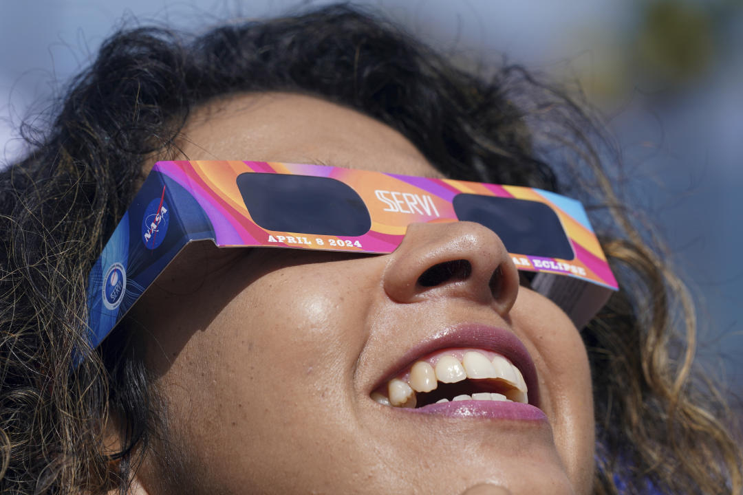 Una mujer observa el eclipse desde Mazatlan, Mexico, Lunes, Abril 8, 2023. (AP Foto/Fernando Llano)