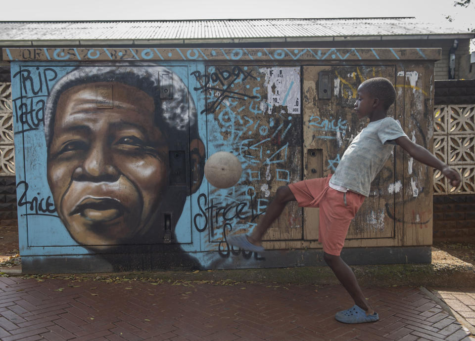 FILE - A child kicks a football in front of a mural of the country's first Black President and leader of the ruling African National Congress (ANC) Nelson Mandela, in Soweto, South Africa, as the country celebrates Freedom Day, on April 27, 2024. South African politics has been dominated by the ruling ANC but this month's election is expected to be a turning point for Africa's most advanced country. (AP Photo, File)