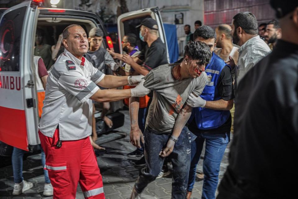 Paramedics hold an injured man at Al-Shifa hospital on Oct. 9 after retrieving him from the scene of an airstrike.<span class="copyright">Saher Alghorra—Zuma Press</span>