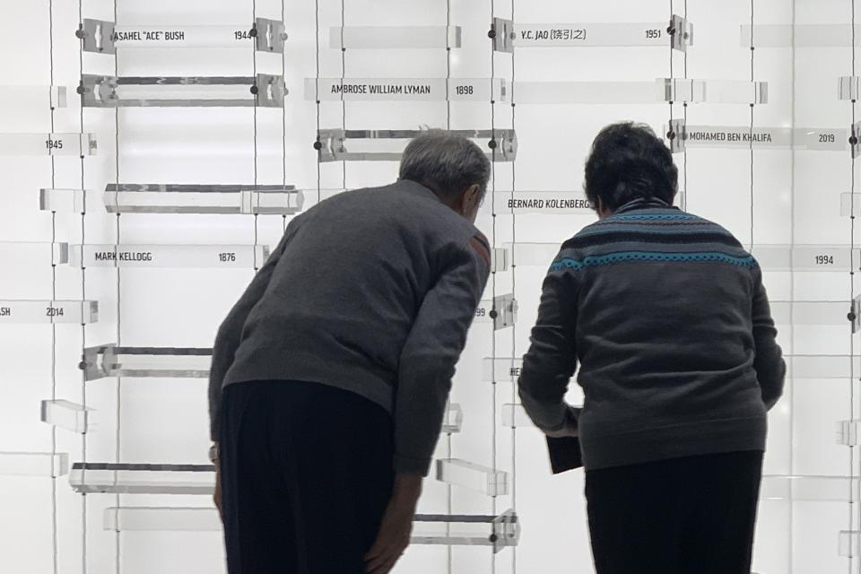 Children of former Associated Press journalist Y.C. Jao, Rao Jian, left, and his younger sister Rao Jiping, right, bow after unveiling their father's name, which was added to the memorial Wall of Honor dedicated to fallen journalists of The Associated Press, at the AP headquarters in New York on Wednesday, Dec. 11, 2019. Jao was executed in April 1951, when Chinese authorities accused him of spying and of counterrevolutionary activities, all owing to his work for AP. (AP Photo/Wong Maye-E)