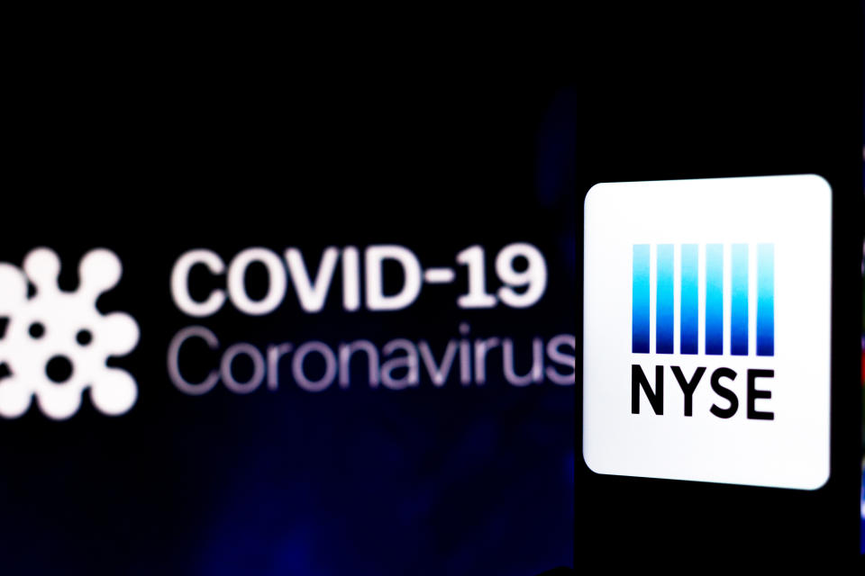 BRAZIL - 2020/04/05: In this photo illustration the New York Stock Exchange (NYSE) logo seen displayed on a smartphone with a computer model of the COVID-19 coronavirus in the background. (Photo Illustration by Rafael Henrique/SOPA Images/LightRocket via Getty Images)