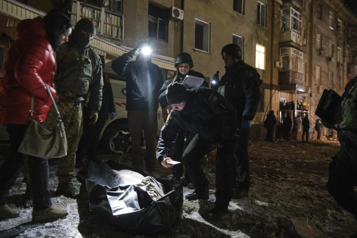 Police officers inspect a dead body which was killed by a Russian rocket attack at residential neighbourhood in Kramatorsk, Ukraine, on Thursday, Feb. 2, 2023. (AP Photo/Yevgen Honcharenko)