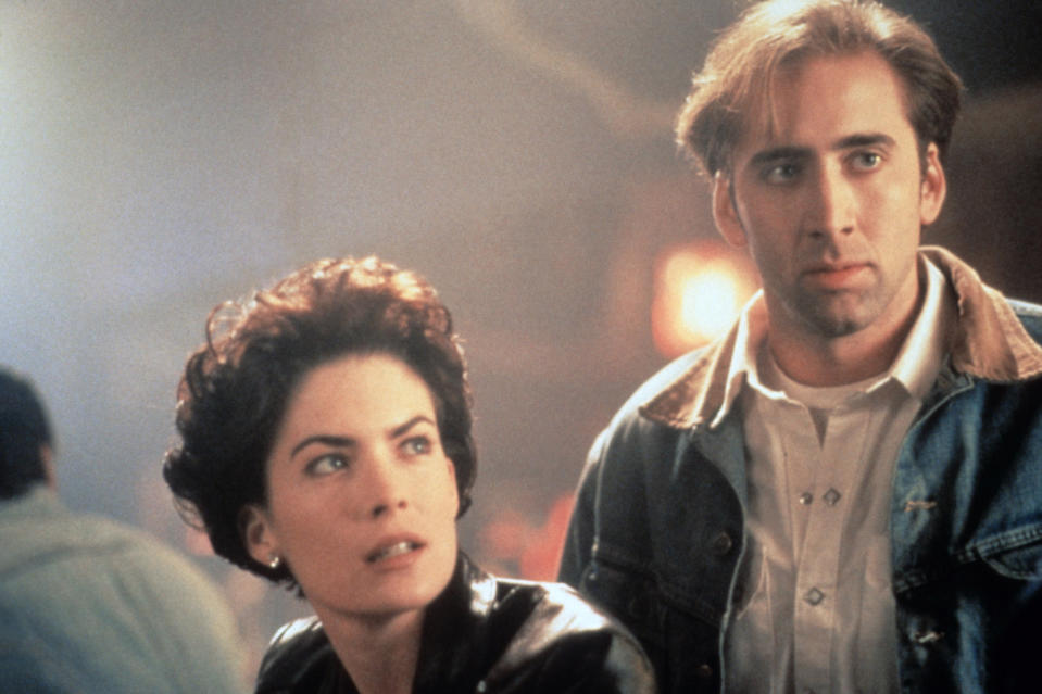 Lara Flynn Boyle and Nicolas Cage staring intensely