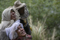 Nepalese honey hunters watch their team leader Devi Bahadur Nepali, climb on a bamboo rope and harvest cliff honey in Dolakha, 115 miles east of Kathmandu, Nepal, Nov. 19, 2021. High up in Nepal's mountains, groups of men risk their lives to harvest much-sought-after wild honey from hives on cliffs. (AP Photo/Niranjan Shrestha)