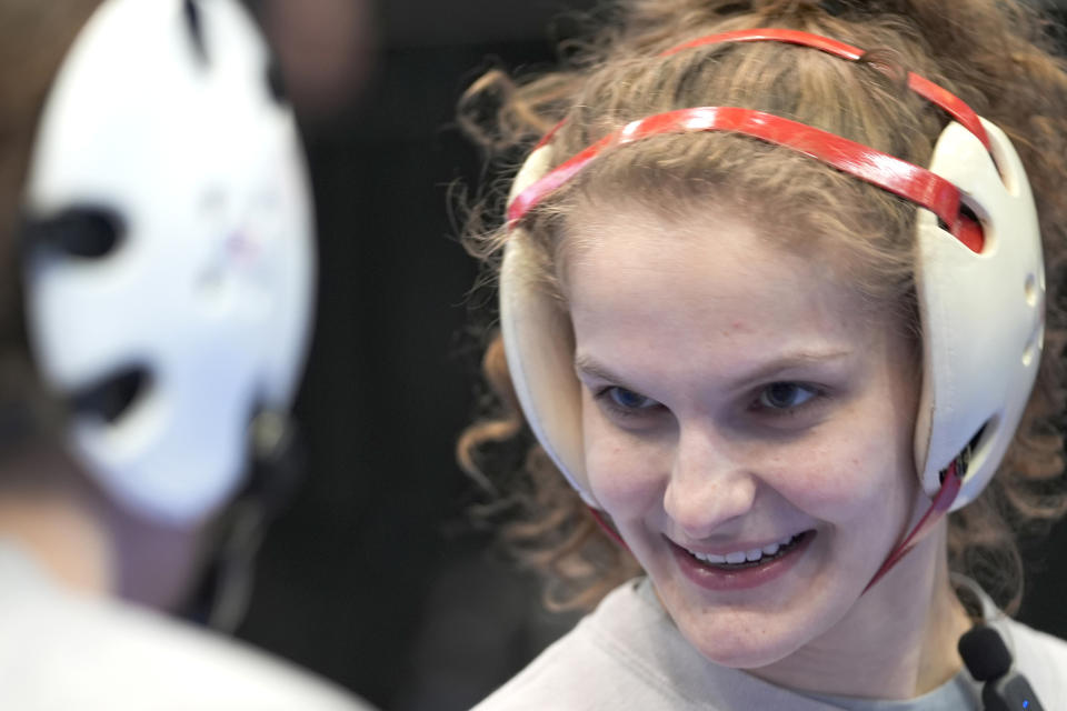 North Central women's wrestling team's Kendra Ryan smiles at Sydney Petzinger during a practice at the Alliant Energy Powerhouse arena in Cedar Rapids, Iowa, Wednesday, March 6, 2024. The team is a national powerhouse even though the program is only a few years old and the school is D-III. (AP Photo/Nam Y. Huh)