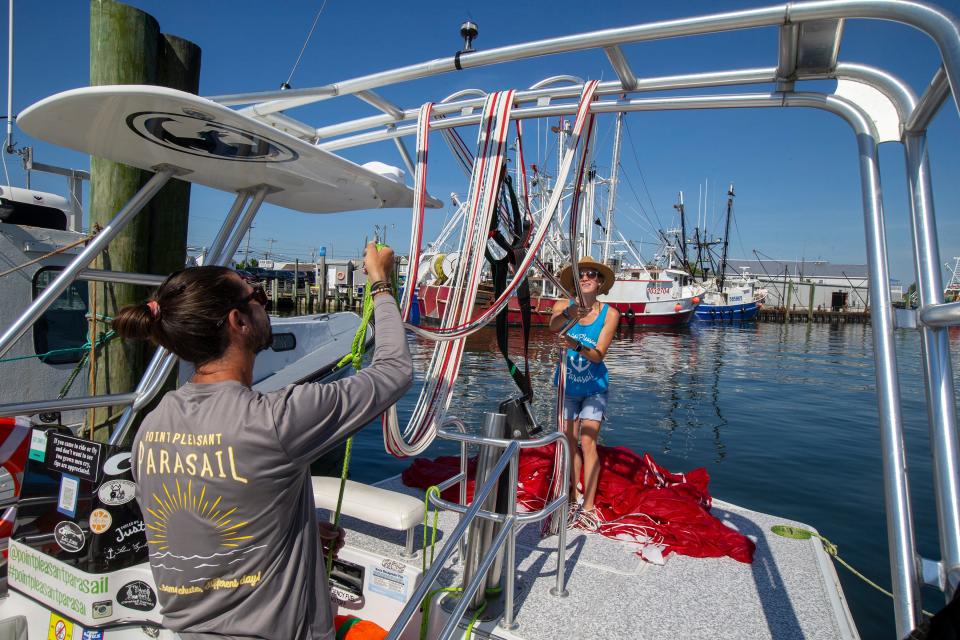 CJ and Libby Titmas, owners of Point Pleasant Parasail, prepare their boat and equipment for a day of parasail excursions in Point Pleasant Beach, NJ Thursday, June 30, 2022. 