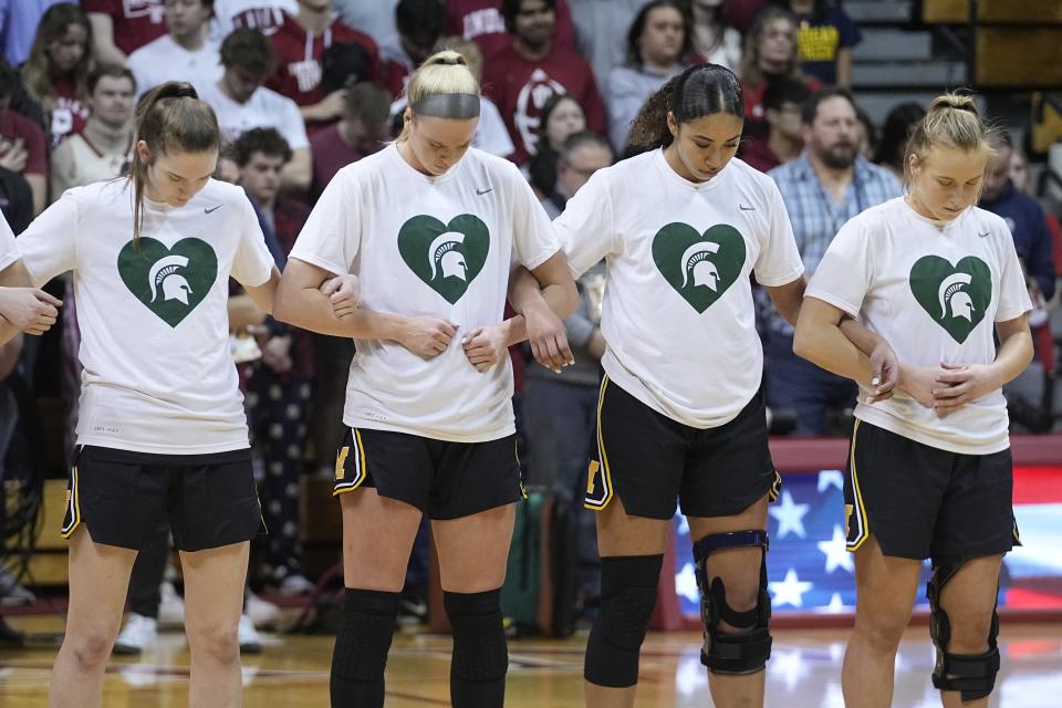 Michigan players pause during a moment of silence for the events that happened on the campus of Michigan State, before the team's NCAA college basketball game against Indiana, Thursday, Feb. 16, 2023, in Bloomington, Ind. (AP Photo/Darron Cummings)