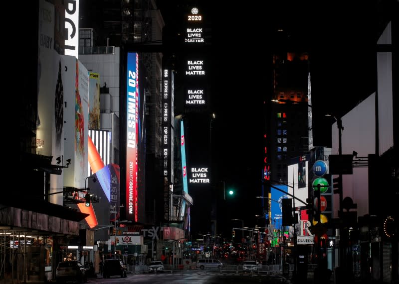 Barricadas y vehículos de la policía de la ciudad de Nueva York bloquean la entrada de Times Square, mientras un letrero muestra "Black Lives Matter" después de un toque de queda debido a las protestas contra la muerte de George Floyd.