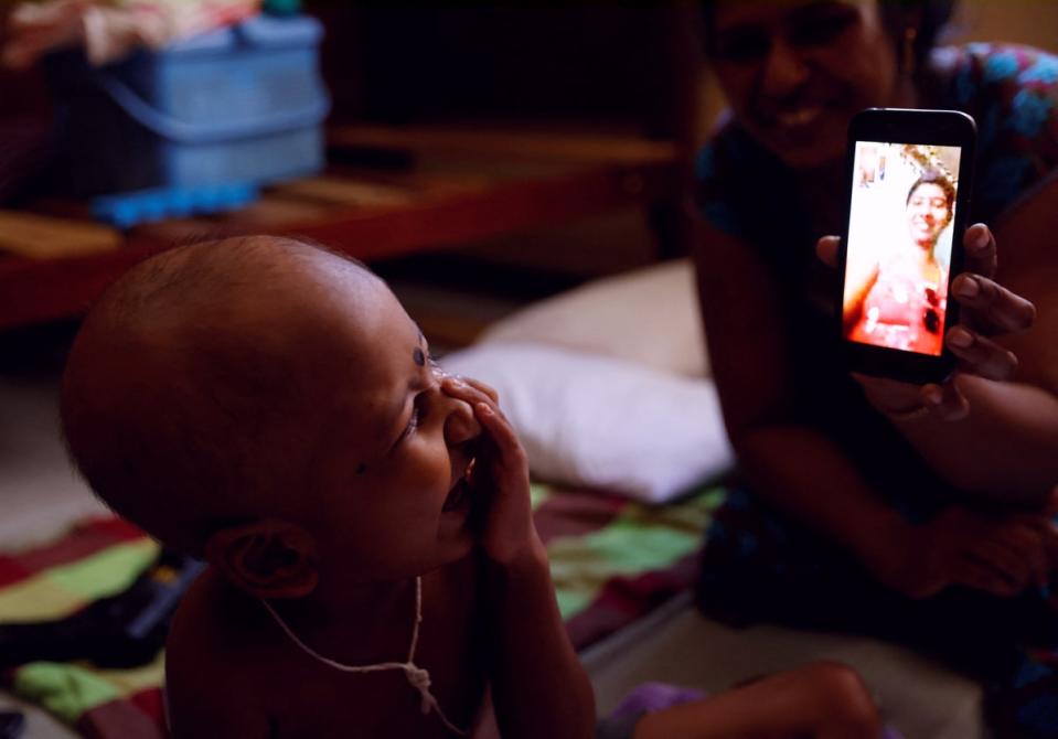 S Saksan laughs as he talks with his mother on a video call (Reuters)