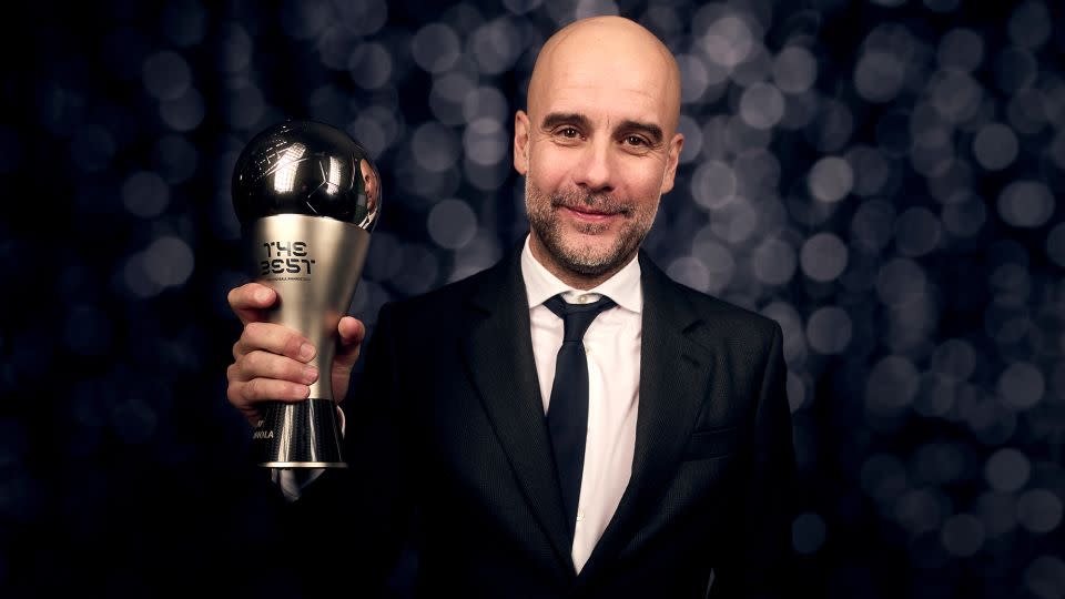 Manchester City Pep Guardiola poses with the trophy after being named the best men's coach in 2023. - Michael Regan/FIFA/Getty Images